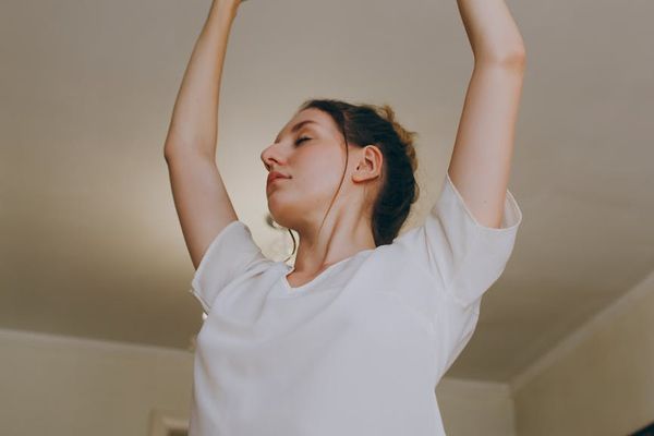A person stretching in a bright, minimalist room.